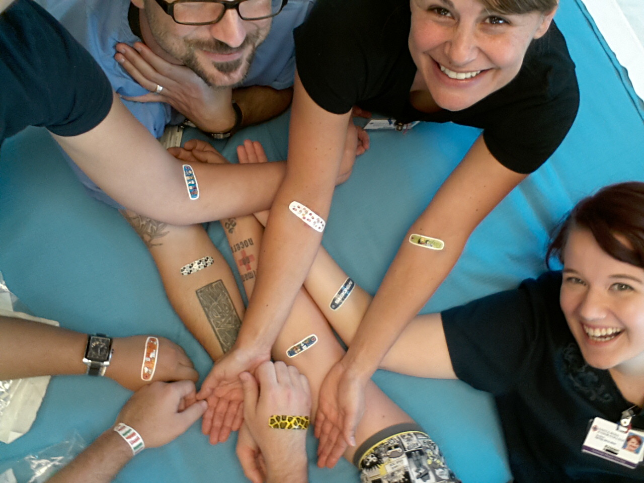 A group of students looking up towards the camera with colorful bandaids on their arms