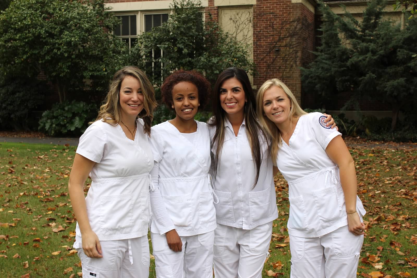 A group of four nursing students posing for a candid photo